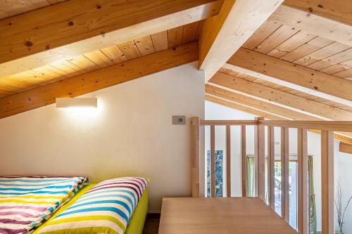 a room with a bed and a wooden ceiling at Agriturismo Bocca Nevese Pino in Tremosine Sul Garda