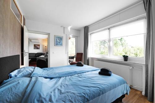 a bedroom with a blue bed and a window at Ut Huuske in Dorsel