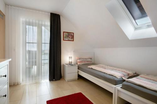 a bedroom with two beds and a window at Appartement Rosi in Ihrlerstein
