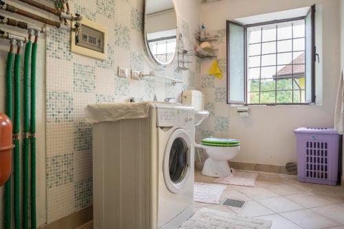 a bathroom with a washing machine and a toilet at Villa Fiore in Lamon