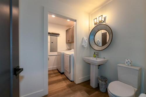 a bathroom with a toilet and a sink and a mirror at Hemlock Cottage · Hemlock Cottage in Pisgah Forest - Pet Friendl in Brevard