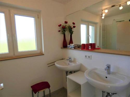 a bathroom with two sinks and a mirror at Fewo Siglinde Schneider in Freiamt