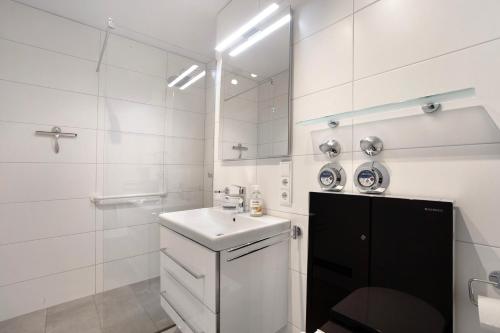 a white bathroom with a sink and a mirror at Ferienwohnung Wölk in Sonthofen
