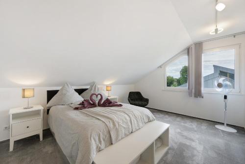 a white bedroom with a large bed and a window at Ferienwohnung Nordschwarzwald in Altensteig