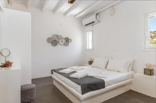 a white bedroom with a bed in a room at Ow Andros Suite 5,Private Whirlpool in Andros