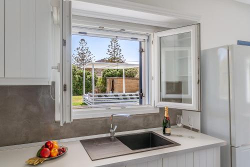 a kitchen with a sink and a window over a counter at Ow Andros Suite 5,Private Whirlpool in Andros