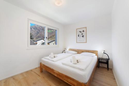 a bedroom with a bed with white sheets and a window at Apartment Mountain Suite in Naturno