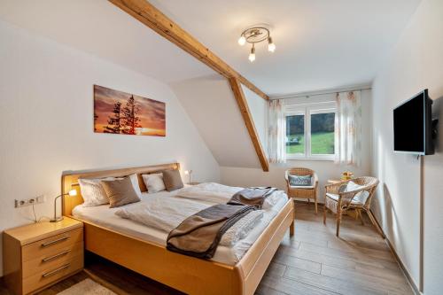a bedroom with a bed and a desk and a tv at Schätzlehof in Oberwinden