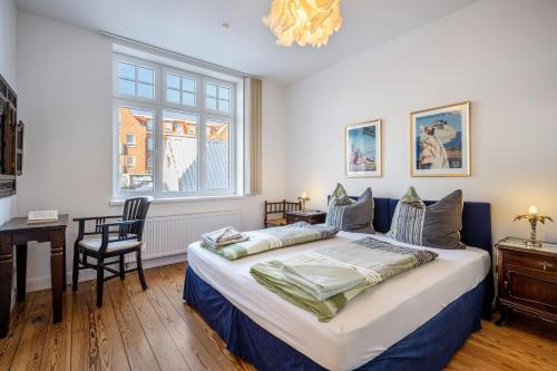 a bedroom with a bed and a desk and a window at Haus Übersee Wohnung Fidji in Travemünde