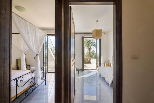 an open door to a bedroom with a bed at Cala D'Aspide in Santa Caterina di Nardò