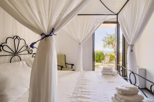 a bedroom with a white bed with a canopy at Cala D'Aspide in Santa Caterina di Nardò