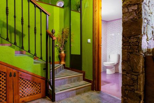 a bathroom with green walls and stairs with a toilet at Casa La Charca in Amavida