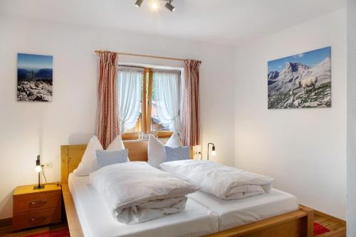 a bedroom with two white beds and a window at Ferienwohnung Zugspitze in Grainau