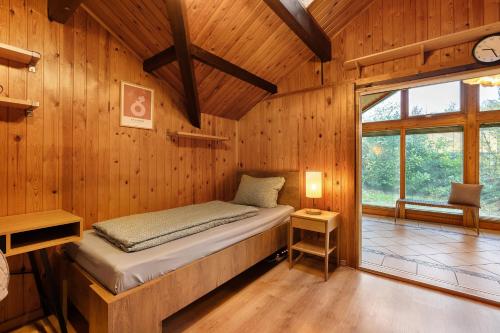 a bedroom with a bed in a wooden room at Dänisches Tiny Haus Brekendorf in Brekendorf