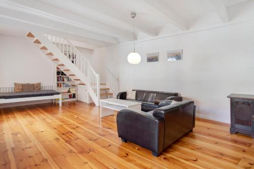 a living room with a couch and a staircase at Alte Seifensiederei 2 in Stralsund