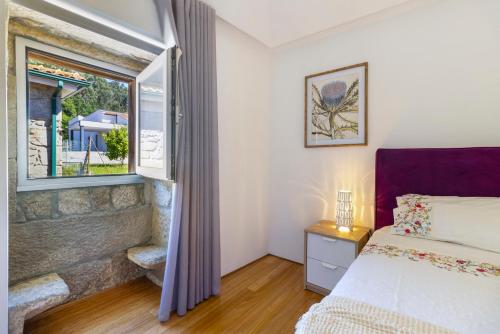 a bedroom with a bed and a window at Casa Da Vovó São in Vila Nova de Cerveira