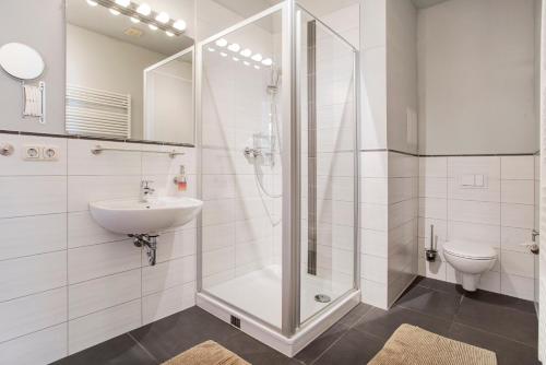 a white bathroom with a shower and a sink at Alte Seifensiederei 2 in Stralsund