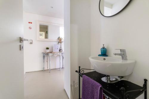 a bathroom with a sink and a mirror at Casa Da Vovó São in Vila Nova de Cerveira