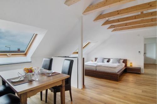 a living room with a dining table and a bed at Aussichtsreich Am See in Uhldingen-Mühlhofen