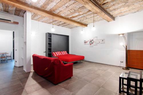 a living room with a red couch and a table at La Sartoria in Porlezza