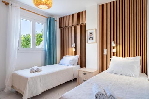a bedroom with two beds and a window at Roys Blu in Kavos