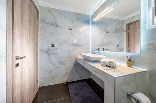 a bathroom with a sink and a tub at Roys Blu in Kavos