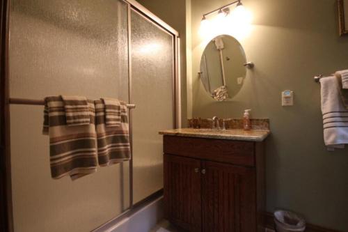a bathroom with a sink and a shower with a mirror at Pine Hill · Pine Hill in Sherwood Forest in Rosman