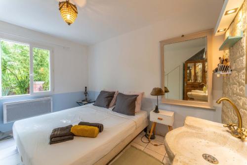 a bedroom with a bed with a mirror and a sink at Plein coeur du Luberon in Apt