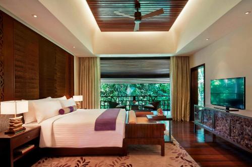a bedroom with a bed and a television and a living room at Mulu Marriott Resort in Mulu