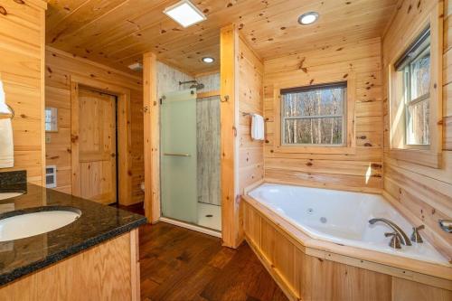 a log cabin bathroom with a tub and a sink at El Escorpio North · El Escorpio North - New Rental in Brevard