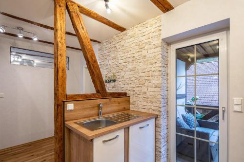 a kitchen with a sink and a brick wall at Ferienwohnung Haseltal in Rotenburg an der Fulda