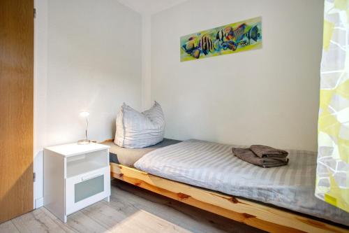 a small bedroom with a bed and a night stand at Bäckerhus - Ferienwohnung 6 in Wiek auf Rügen