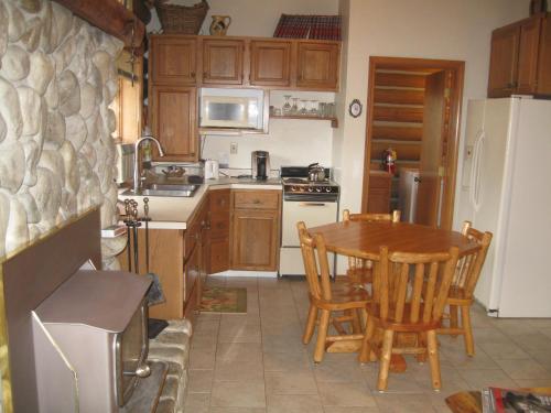 a kitchen with a table and chairs and a refrigerator at Rye Creek Lodge in Darby