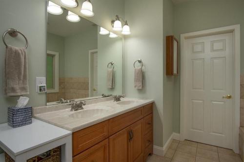 a bathroom with a sink and a large mirror at Hummingbird Hideaway · Hummingbird Hideaway in Connestee Falls in Brevard