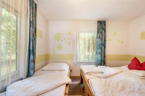 a room with three beds and a window at Bugalow 16 - Finnhütte in Niesky