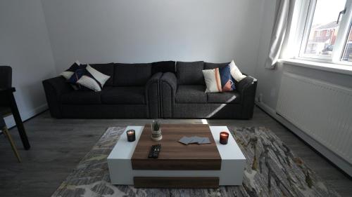 a living room with a couch and a coffee table at EliteStays in Bilston