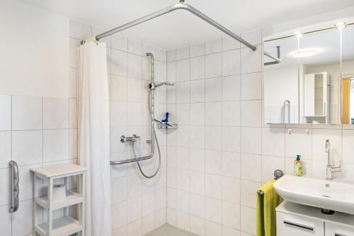 a white bathroom with a shower and a sink at Ferienhaus Albert in Bühl