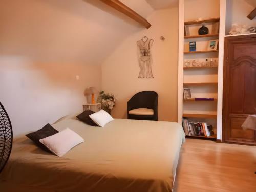 a bedroom with a bed and a black chair at Les Chambres Des Chtis in Abbeville