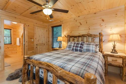 a log cabin bedroom with a bed and a ceiling fan at Hideaway Cabin · Hideaway Cabin in Cedar Mountain in Cedar Mountain
