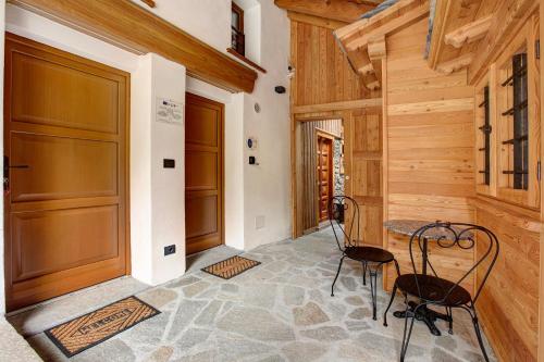 a hallway with two chairs and a table in a house at Aux Pieds du Malatra' 1 in Saint-Rhémy-en-bosses