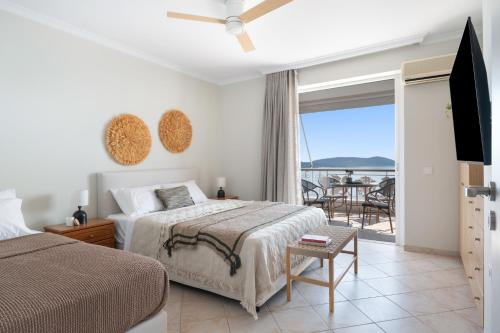 a bedroom with a bed and a view of the ocean at Panorama Apartments in Skoutari