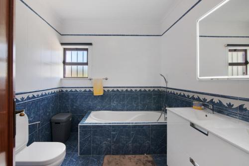 a bathroom with a tub and a toilet and a sink at Villa Neves in Albufeira