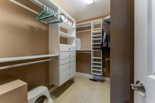a walk in closet with white drawers and shelves at Bearly Ruffin It · Bearly Ruffin It in Connestee Falls in Brevard