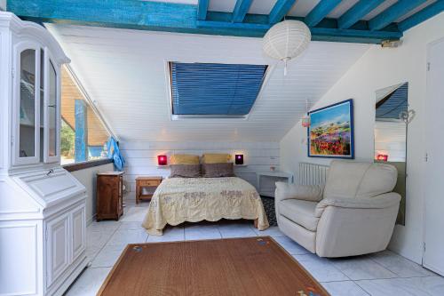 a bedroom with a bed and a couch and a chair at Espace, calme, confort in Saint-Michel-Escalus
