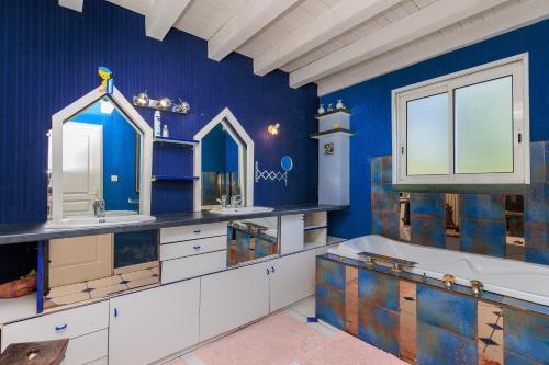 a blue bathroom with a tub and two sinks at Espace, calme, confort in Saint-Michel-Escalus