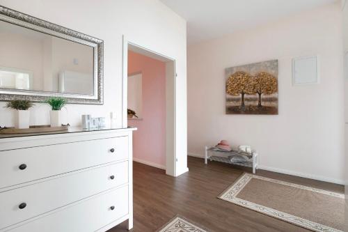a bedroom with a white dresser and a mirror at Haus Eiderblick in Horst