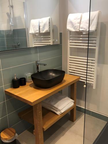 a bathroom with a black bowl sink on a wooden table at La Baïta De La Foux in La Foux d'Allos