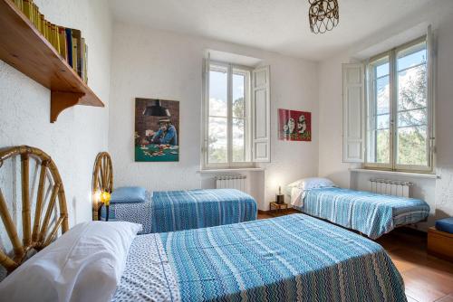 a bedroom with two beds and two windows at Palazzetto Bovini in Perugia