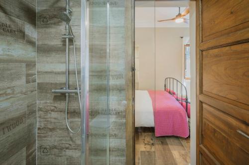 a shower with a glass door in a bedroom at Finca El Aguilojo in Mombeltrán