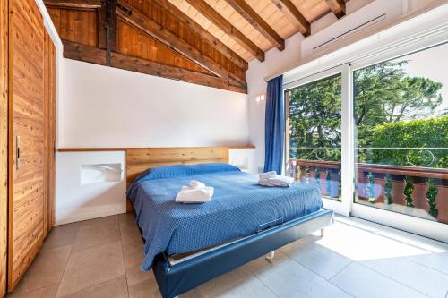 a bedroom with a bed and a large window at Al segnavento Montese in Toscolano Maderno